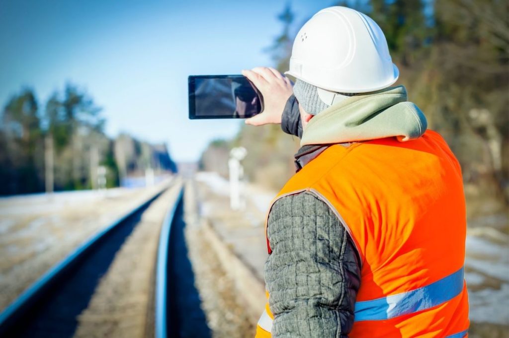 Railway track engineer taking a photo of the line