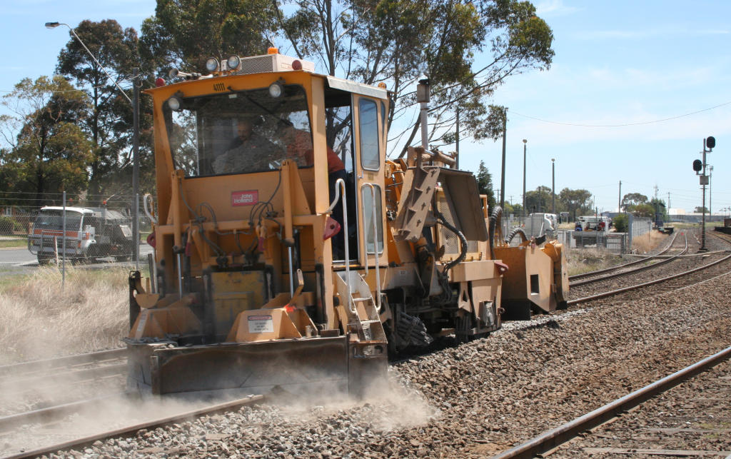 A ballast regulator shaping newly placed ballast